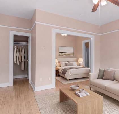 A bedroom with a bed, a couch, and a table.