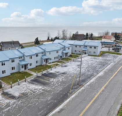 A row of houses with a road in front of them.