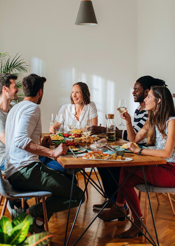 A group of people are sitting around a table enjoying a meal together.
