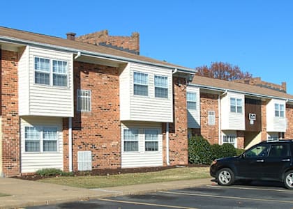 an apartment building with cars parked in front of it