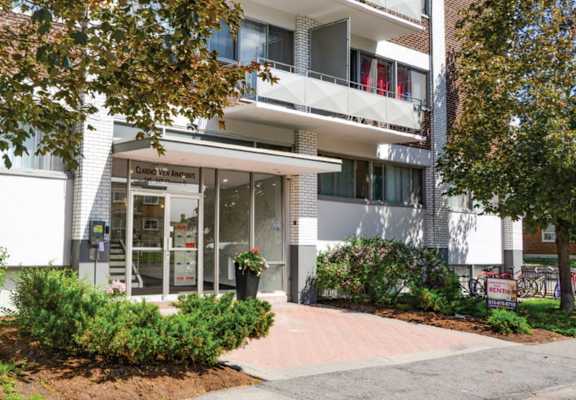 a white apartment building with a tree in front of it