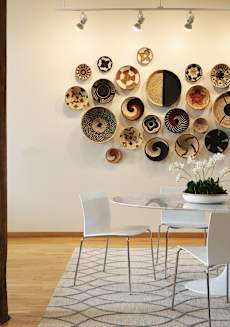 a dining room with a table and chairs and plates on the wall