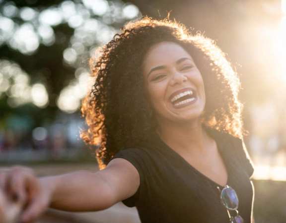 a woman laughing while holding another persons hand at Hampton in Highland Apartments, Highland, 46322