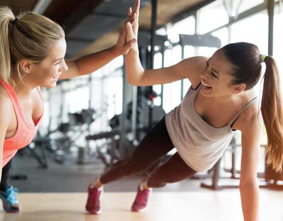 two women giving each other a high five in a gym at Hampton in Highland Apartments, Indiana, 46322