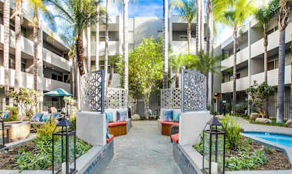 A courtyard with a pool surrounded by buildings and trees.
