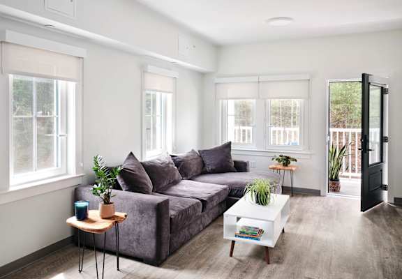 a living room with white walls and a gray couch
