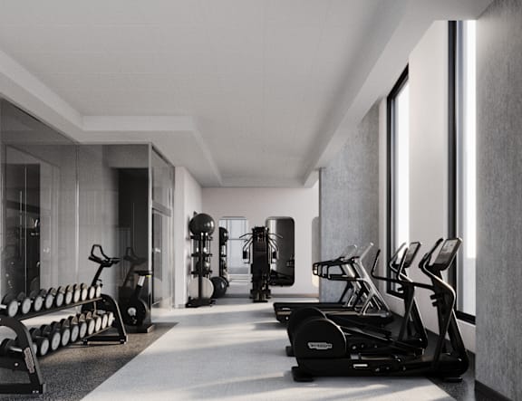 A black and white image of a gym with treadmills, exercise bikes, and other equipment.