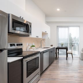 a kitchen with stainless steel appliances and a door to a balcony  at The Loop at Green Lake, Seattle, Washington