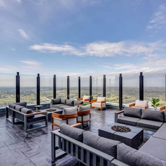 a lounge area with couches and tables overlooking the city at Citizen on Jasper, Edmonton, Alberta