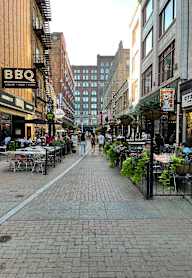 A street with a BBQ restaurant on the left.