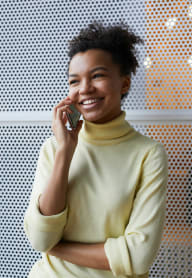 a smiling woman talking on a cell phone at Townhouse Covina Apts, Covina, CA 91724