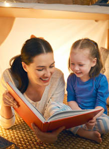 A woman and a child are reading a book together.