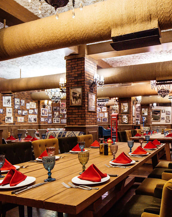 a restaurant with tables and chairs and plants