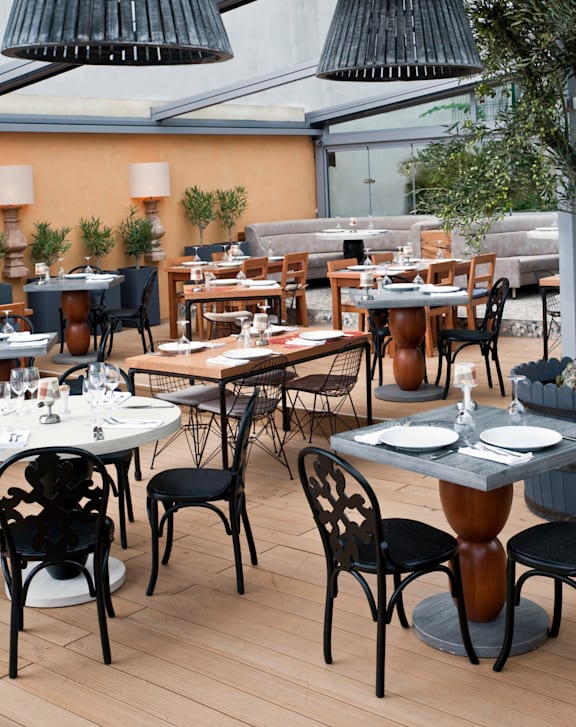 A restaurant with tables and chairs and plants.