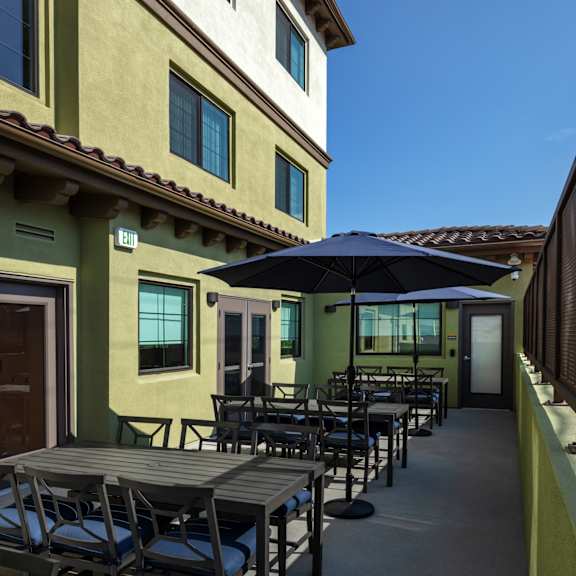 The front of the Mesa Vista Apartments building with a flag flying in the background.