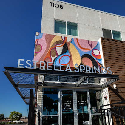 The entrance to Estrella Springs with a colorful mural above it.