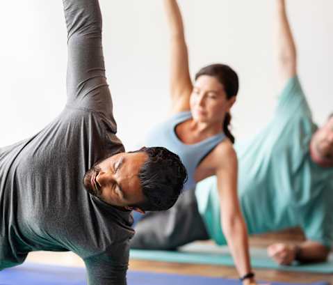 A group of people practicing yoga in a studio.