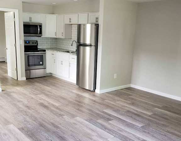 A kitchen with a stove top oven and a refrigerator.