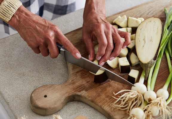 a man cutting vegetables on a cutting board