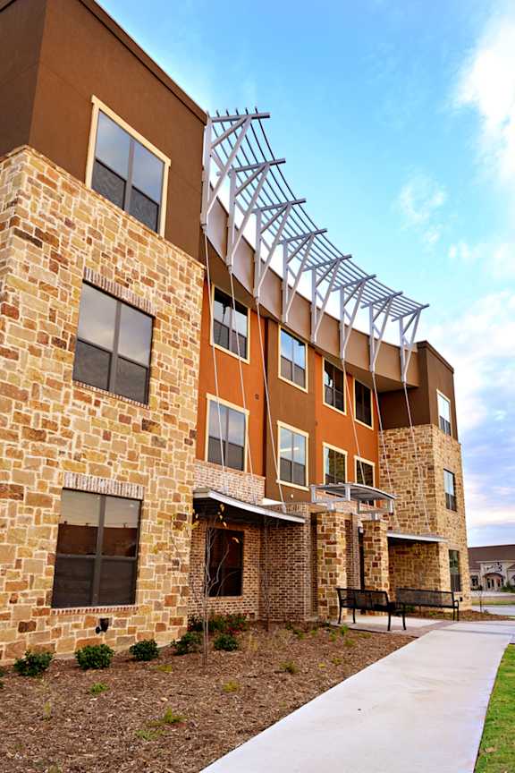 an exterior view of a building with a bench in front of it