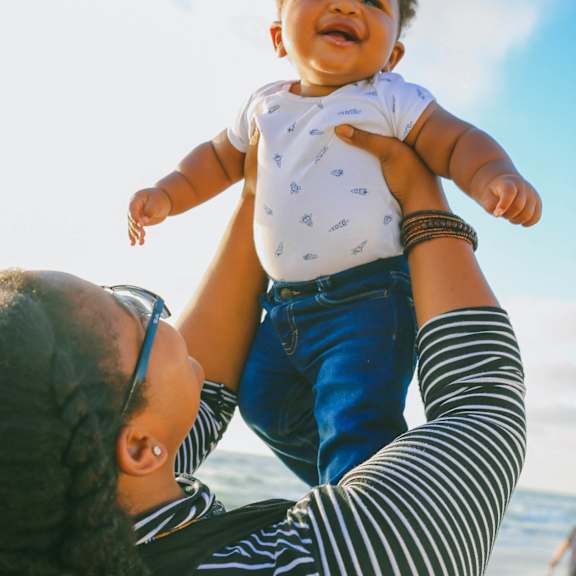 Woman lifts a baby up at Arbor Pointe, Lakewood, Washington