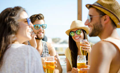 a group of friends drinking beer at a beach bar