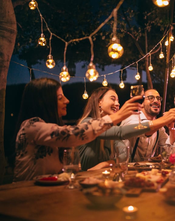 a group of people sitting around a table drinking wine