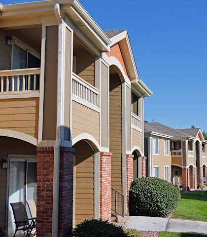 a row of apartments with a sidewalk and grass
