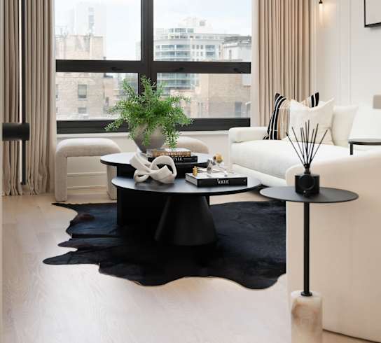 A black and white living room with a large window at Chateau on Wells, Chicago, Illinois