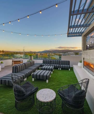 a roof deck with lounge chairs and a fireplace
