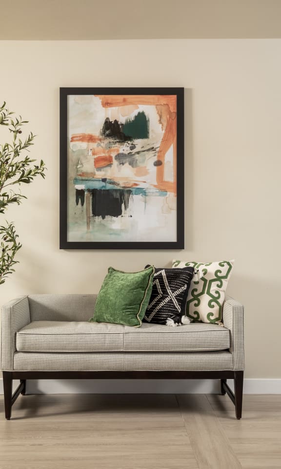 a couch with colorful pillows and a painting on the wall