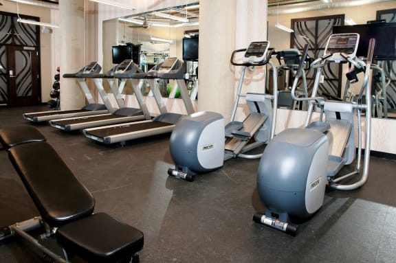a gym with cardio equipment and weights on the floor at Buzza Lofts of Uptown, MN 55408