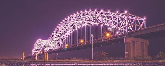 A boat is sailing under a bridge.