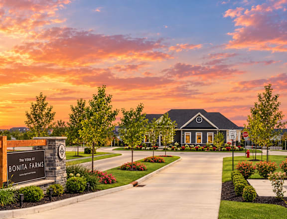 The image shows a beautiful sunset view of a residential area with a sign that reads "Bonita Farms".