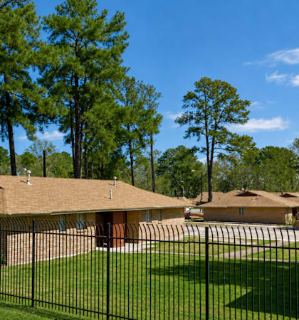 A sign that says "Woodlands" is in front of some houses.