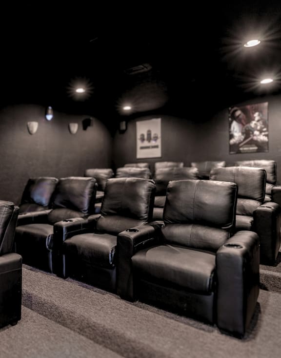 A row of black leather reclining chairs are lined up in a room.