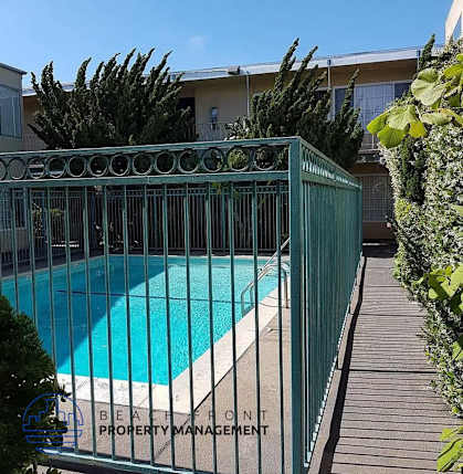 a swimming pool is behind a wrought iron fence