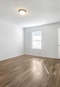 A room with wooden flooring and a window.