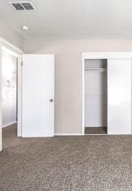 A room with two white doors and a carpeted floor.