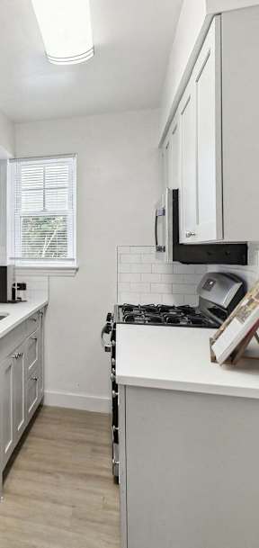 a renovated kitchen with white cabinets and a white counter top