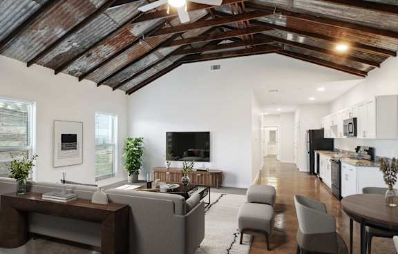 A modern living room with a wooden ceiling and a grey sofa.
