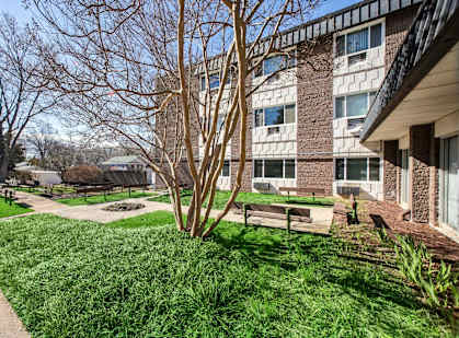 a courtyard with benches in front of a building