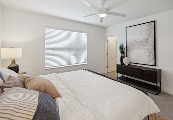 a bedroom with a large bed and a ceiling fan