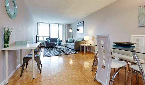 a living room with a table and chairs in front of a window