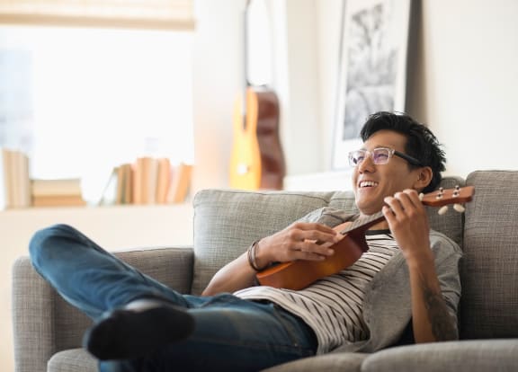 Man relaxing playing Ukelele