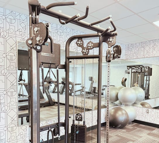 A gym with a weight machine in the foreground.