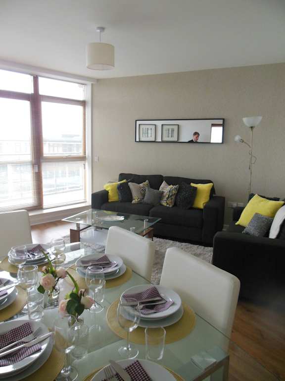 a living room and dining room with a glass table and couches