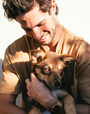 a man holding a small dog on his lap