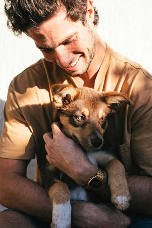 a man holding a small dog on his lap