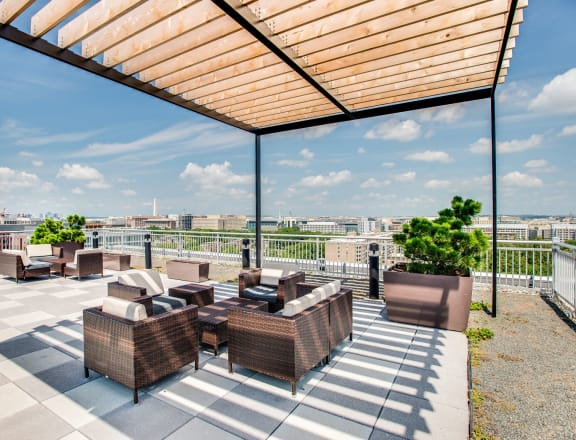 a roof terrace with couches and chairs and a view of the city